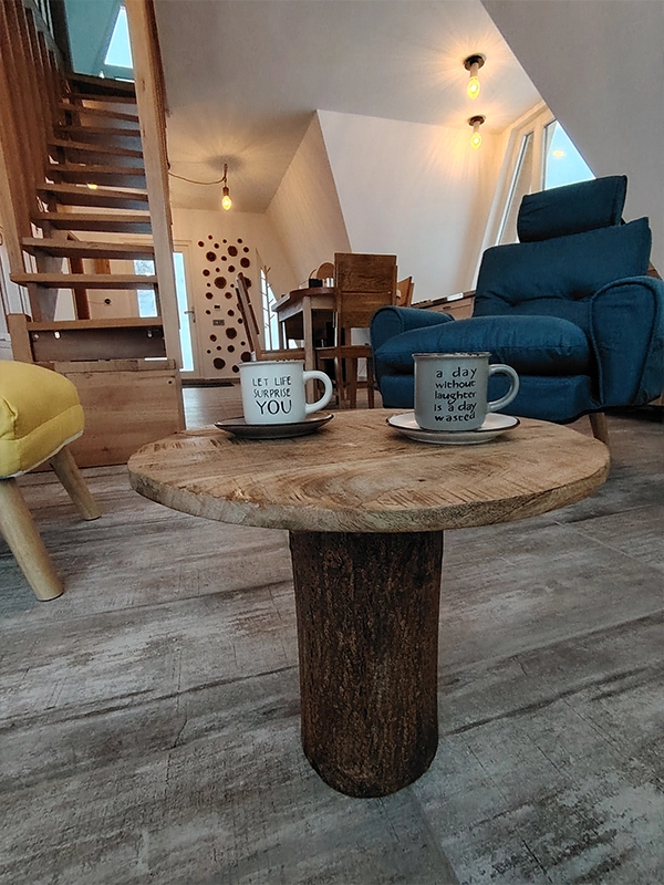 ouă cești de cafea pe o măsuță rustică, într-un living luminos și primitor de la Alloria